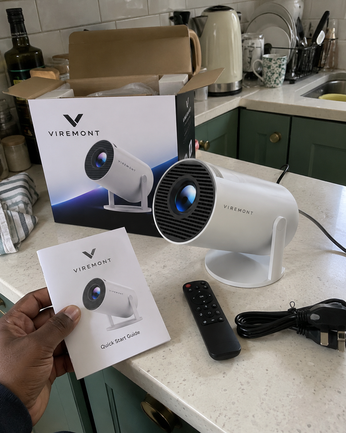 Illustrative Viremont setup: Cylindrical projector and quick start guide on kitchen counter