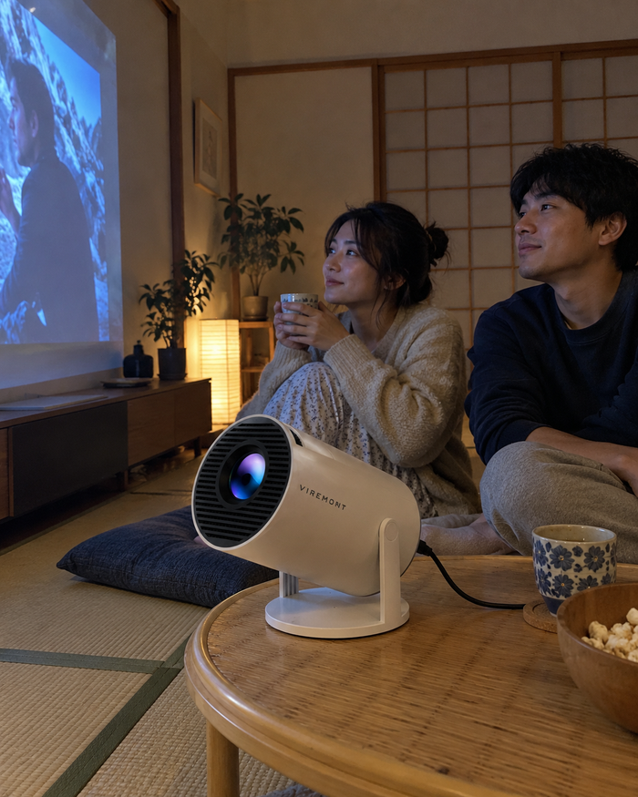 Illustrative Viremont setup: Couple watching movie on floor beside cylindrical projector